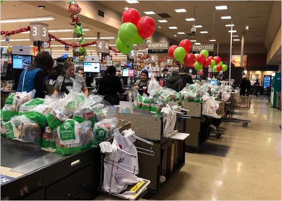 Cashiers packing groceries into $5 and $10 bags to donate