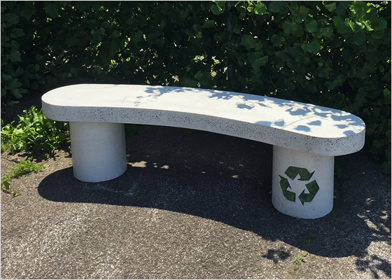 Un banc de parc marqué du symbole de recyclage.