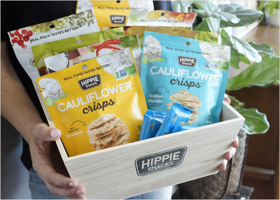 Person holding a box of Hippie Snacks products.