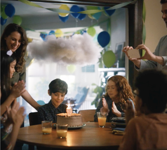 In this image, a group of people is celebrating a child's birthday.
