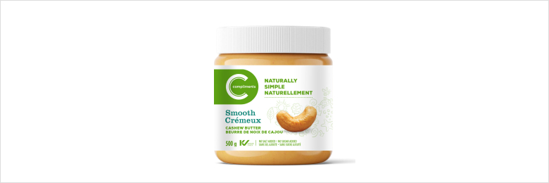 A jar of Compliments Naturally Simple Smooth Cashew Butter with a white lid and label, featuring an image of cashews, and text indicating 500g and Kosher certification.